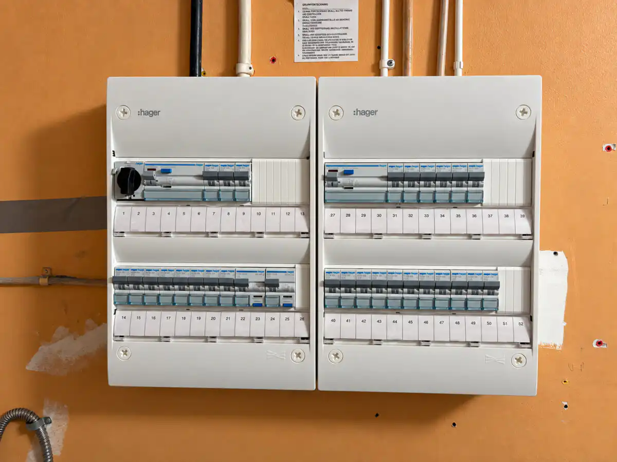 Två nya elcentraler med automatsäkringar och märkta grupper på samma vägg, efter byte utfört av Ampy